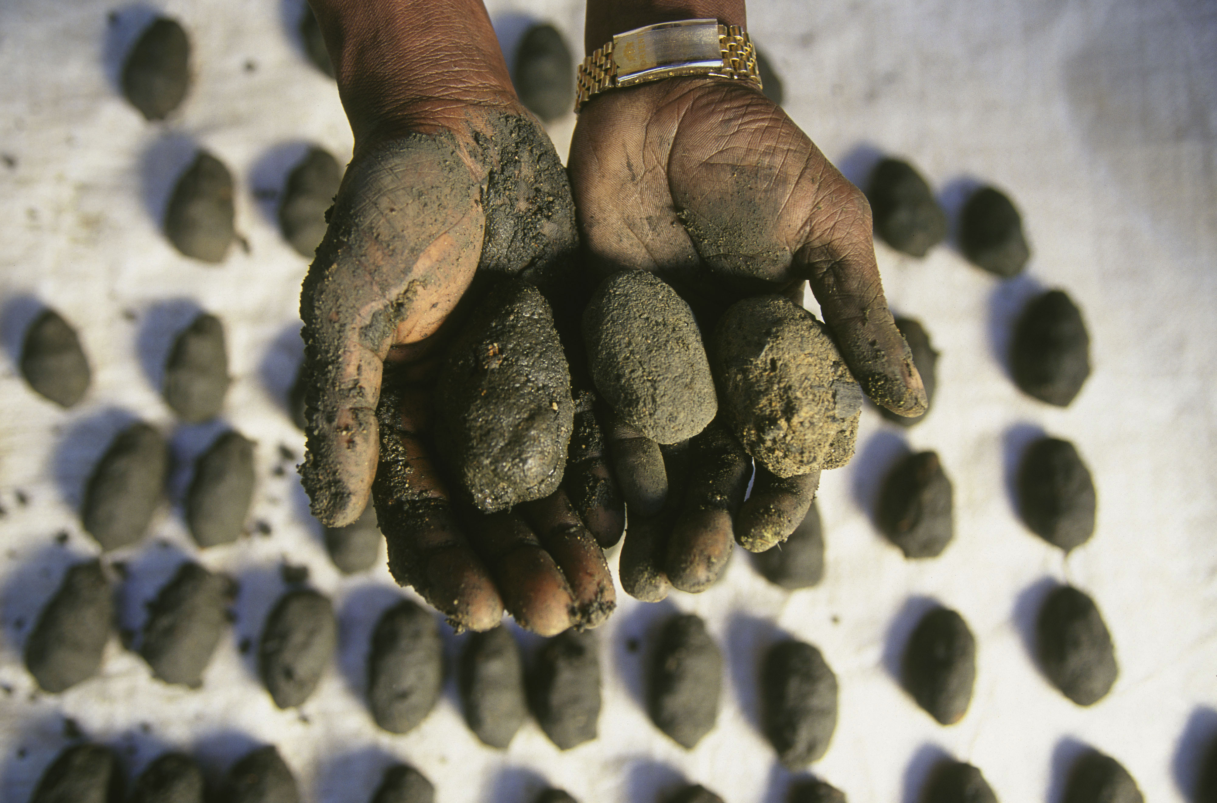 Making green charcoal out of dried plants, wood ash and sand in a village near Udzungwa Mountains National Park, Tanzania